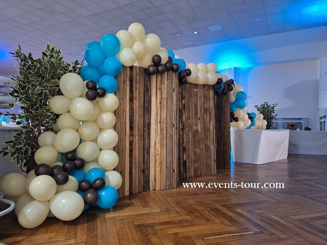 Décoration de salle avec paravent en bois et guirlande organique en ballons.