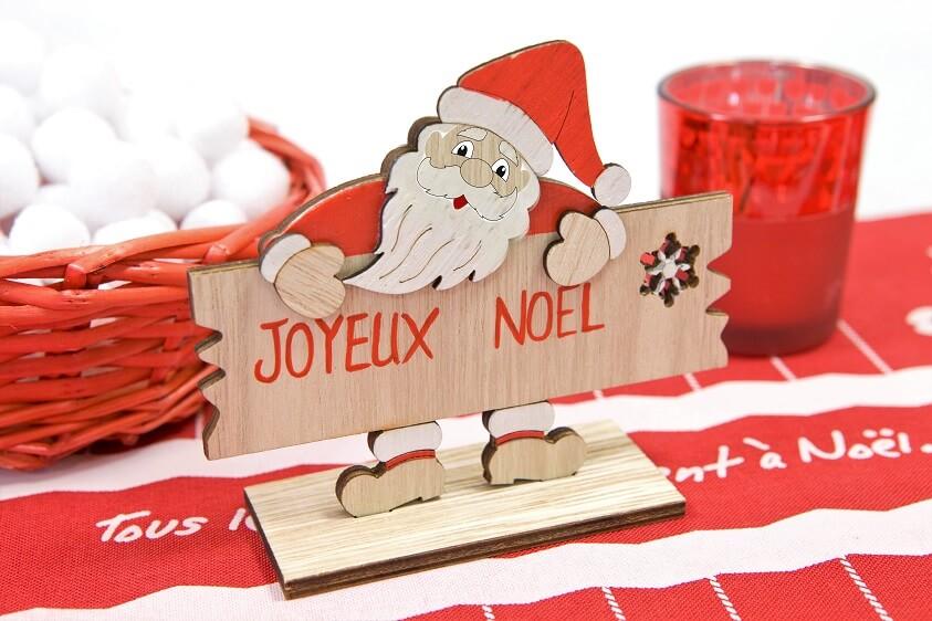 Dek0480 decoration pere noel en bois accoude sur pancarte joyeux noel